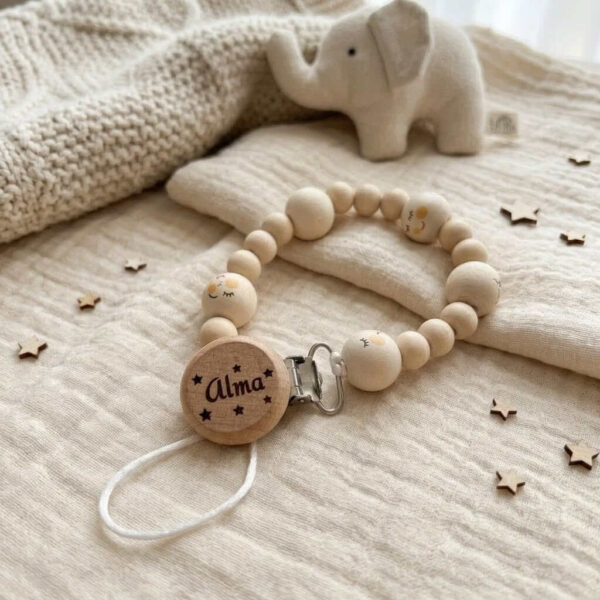 Personalizēts knupīša turētājs ar koka pērlītēm, metāla klipsi un koka detaļu ar vārdu Alma