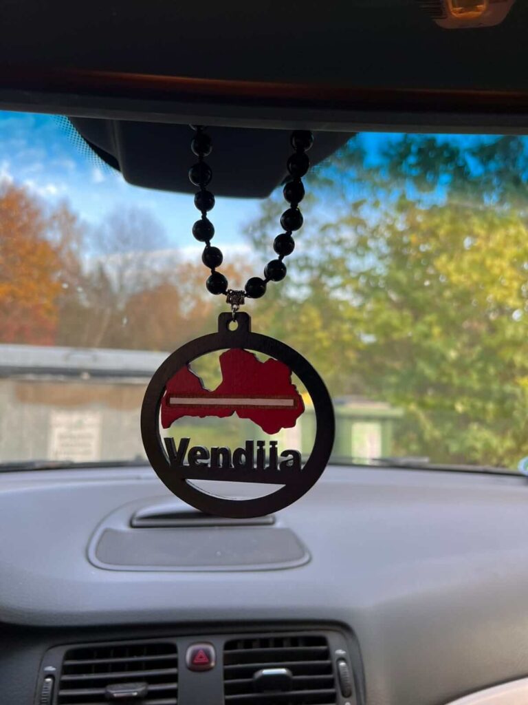 Auto piekariņš ar Latvijas karoga motīvu un personalizētu vārdu pie atpakaļskata spoguļa